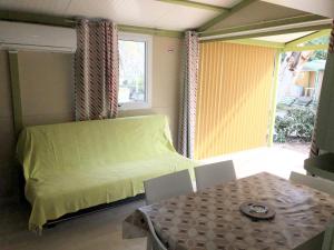 a small bedroom with a bed and a table at Camping A Torra in Galeria
