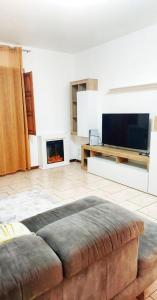 a living room with a couch and a flat screen tv at Mar&Mat in Giarre