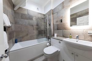 a bathroom with a toilet and a sink and a bath tub at Bryn Derwen with Private Car Park in Llandudno +47 photos