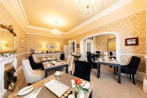 a restaurant with tables and chairs and a fireplace at Bryn Derwen with Private Car Park in Llandudno