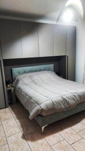 a bedroom with a large bed with a blue headboard at Mar&Mat in Giarre