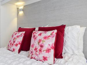 a bed with red and white pillows on it at Newcastle Lodge in Thornton +12 photos