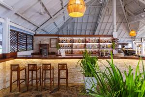 a restaurant with stools and a bar in a building at VOI Andilana Beach Resort in Nosy Be