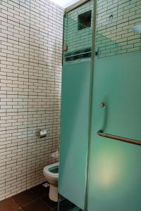 a bathroom with a toilet and a glass shower door at Crystal Bricks Apartments in Port Harcourt