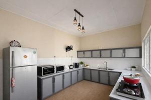 a kitchen with a white refrigerator and a sink at The Deane Residence Family Room in Colombo +15 photos