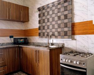 a kitchen with a sink and a stove top oven at Crystal Bricks Apartments in Port Harcourt