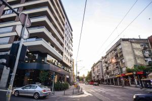a car driving down a city street with buildings at Dreams Hill Studio in Čukarica