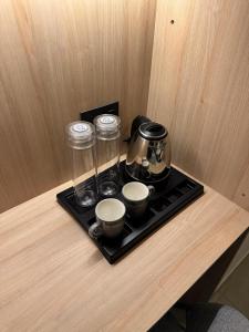 a tray with a coffee maker and cups on a table at The Zen Retreat in Kozhikode