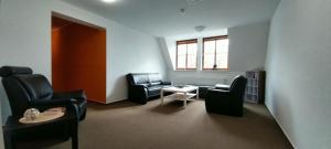 a waiting room with chairs and a table and a window at BBZ Burg Weißensee in Weißensee