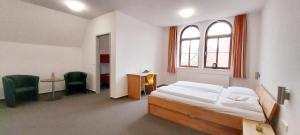 a bedroom with a bed and a desk and a window at BBZ Burg Weißensee in Weißensee
