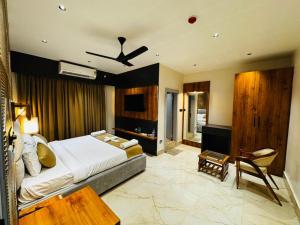 a bedroom with a king sized bed and a table at Mannat Hotel in Tezpur