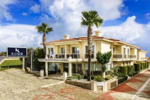 ein Gebäude mit Palmen davor in der Unterkunft Kamer Exclusive Hotel & Suites in Cesme
