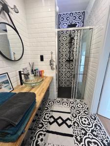 a bathroom with a shower with a black and white rug at SeaView Apartament in Gdańsk Letnica +95 photos