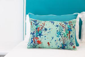 a pillow on a bed with a blue background at YourHome - Villa Allegria in Positano