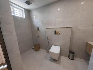 a bathroom with a toilet and a shower at The Zen Retreat in Kozhikode