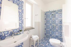 a blue and white bathroom with a tub and a sink at YourHome - Villa Allegria in Positano +52 photos