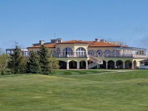 a large building on a golf course with a green at Ines - Golf und Meer Bulgarien in Balchik