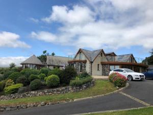 a house with a car parked in front of it at The Walnut Retreat Castlewellan in Ballyward