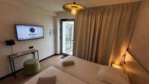 a bedroom with a bed and a tv on the wall at Abalys Hotel in Brest