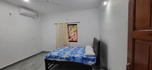 a small bedroom with a bed and a window at Daji Dhabolkar house in Mandrem