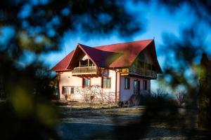 a house with a red roof at Cabana Apus de Soare in Râșca