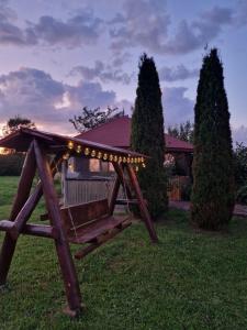 a wooden swing in the yard of a house at Cabana Apus de Soare in Râșca