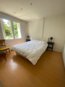 a bedroom with a white bed in a room with two windows at Maison luxueuse proche de Paris centre in Aulnay-sous-Bois