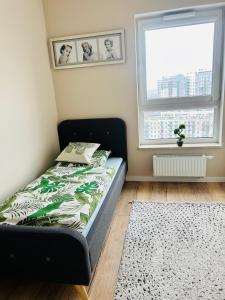 a bed in a room with a window at SeaView Apartament in Gdańsk Letnica