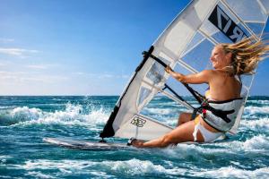 a woman riding a wind sail on the ocean at 14 Penguin Place, Melkbosstrand in Melkbosstrand