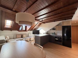 a kitchen and living room with a large wooden ceiling at Apartamentos St.Anton Suites Benasque in Benasque