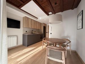 a kitchen and dining room with a wooden table and chairs at Apartamentos St.Anton Suites Benasque in Benasque