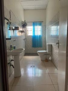 a white bathroom with a sink and a toilet at Inkindi House in Kigali +37 photos