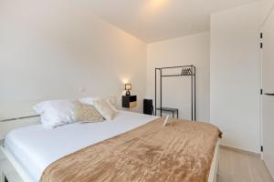 ein Schlafzimmer mit einem großen weißen Bett und einem Spiegel in der Unterkunft Flat Scarpato in Kortemark