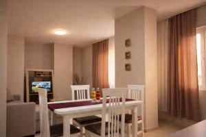 a dining room with a white table and chairs at Dahlila's Home near Lake Ohrid in Pogradec