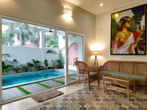 a living room with a bench and a swimming pool at The Balified Villa in Pondicherry