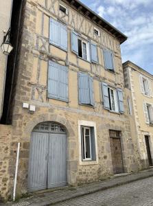 an old stone building with a door and windows at Casa 17 Confolens in Confolens