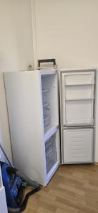 a white refrigerator with its door open in a room at Monteur und Messewohnung in Rodgau