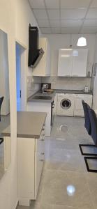 a kitchen with white cabinets and a stove top oven at Monteur und Messewohnung in Rodgau