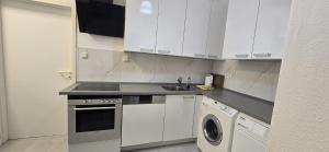 a kitchen with white cabinets and a washing machine at Monteur und Messewohnung in Rodgau +17 photos