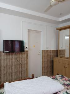 a bedroom with a bed and a television on the wall at Orchid Woods Garden in Trivandrum