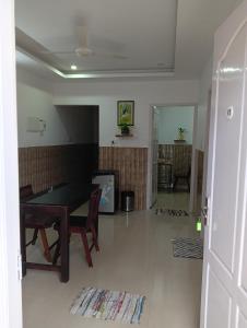 a living room with a table and a dining room at Orchid Woods Garden in Trivandrum