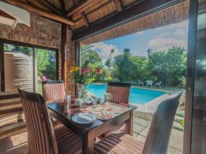 a dining room with a table and chairs and a pool at Amani Guest Lodge in Port Elizabeth +8 photos