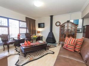 a living room with a couch and a fireplace at Amani Guest Lodge in Port Elizabeth