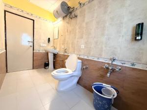 a bathroom with a toilet and a sink at Laavish 7 Hotel in Bangalore