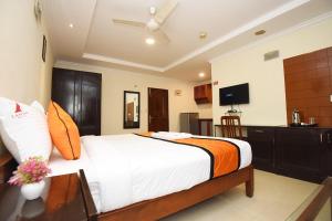 a bedroom with a large bed and a television at Laavish 7 Hotel in Bangalore