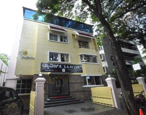 a yellow building with a sign in front of it at Laavish 7 Hotel in Bangalore