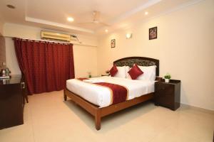 a bedroom with a bed and a red curtain at Laavish 7 Hotel in Bangalore