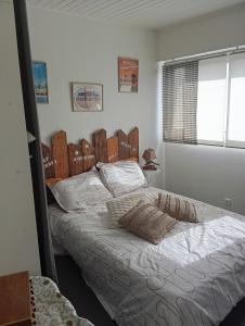 a bedroom with a large bed with white sheets at T2 Charmant et calme in Andernos-les-Bains