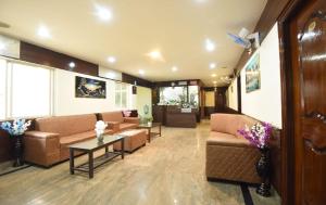 a living room with couches and a table at Laavish 7 Hotel in Bangalore +2 photos