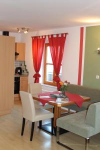 a living room with a table and red curtains at Pihringer's Moststub'n in Amstetten